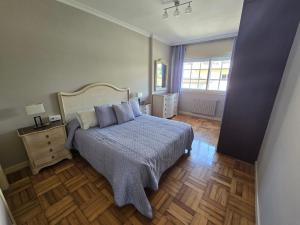 a bedroom with a large bed with a blue blanket at Casa en la playa de Panxón in Nigrán