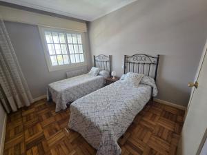 a bedroom with two beds and a window at Casa en la playa de Panxón in Nigrán