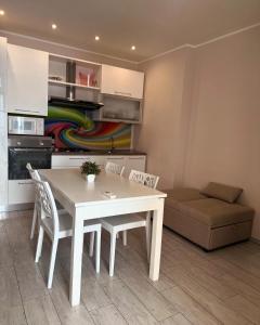 a kitchen and dining room with a table and a couch at Central Home in Taranto