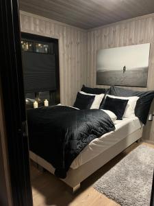 Un dormitorio con una cama con almohadas blancas y negras. en Brand new house close 2 Skiresort, en Hemsedal