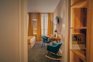 a hotel room with a bed and a desk and chairs at Globe Et Cecil in Lyon