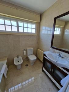 a bathroom with a sink and a toilet and a mirror at Casa en la playa de Panxón in Nigrán +22 photos