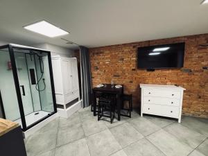a kitchen with a table and a tv on a brick wall at 69 apartaments II in Panevėžys