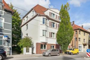 a white building with cars parked in front of it at Aparties I Bielefeld mitte I voll ausgestattet I hochwertige Betten I Top Lage in Bielefeld