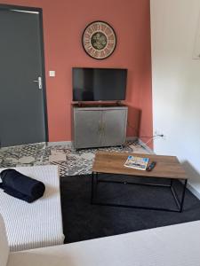 a living room with a tv and a coffee table at Templemars proximité Lille 4 personnes jardin in Templemars