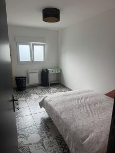 a white bedroom with a bed and a window at Templemars proximité Lille 4 personnes jardin in Templemars