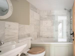 a bathroom with a toilet and a tub and a sink at Holwell Farmhouse in Tiverton