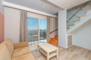 a living room with a couch and a large window at Pansion Ermioni in Skala