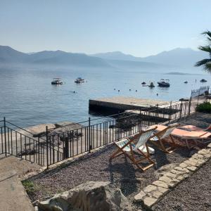 a beach with chairs and boats in the water at Studio apartman Monte 1 in Krasici