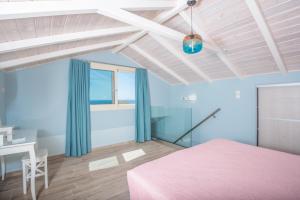 a bedroom with a pink bed and a desk at Pansion Ermioni in Skala