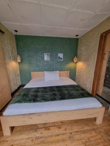 a bed in a room with a green wall at Khaya Nzuri Musanze in Gasanze