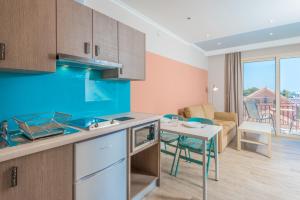 a kitchen and living room with a table and a couch at Pansion Ermioni in Skala