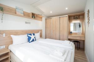 a bedroom with a bed with white sheets and towels at Ostseecamp Küstenkind, eingezäuntes Grundstück in Scharbeutz