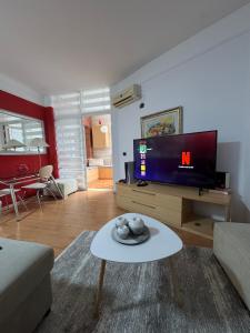 ein Wohnzimmer mit Fernseher und Tisch in der Unterkunft Gerald 1 in Tirana