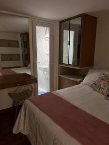 若昂佩索阿Paradise flat Beats的卧室里有一张床、一张书桌和一面镜子