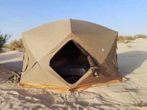 a tent sitting on the beach in the sand at Private Camp25km-from DOUZ in Douz