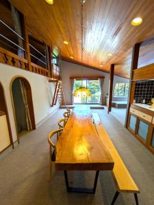 un grande tavolo in legno in una stanza con sedie di Sotoura Resort House 涛Tõ! BBQ-MAX10ppl-4min to Sotoura beach! a Shimoda