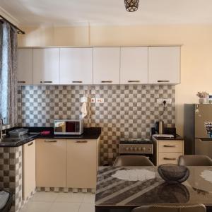 a small kitchen with white cabinets and a table at Ngong homes in Ngong