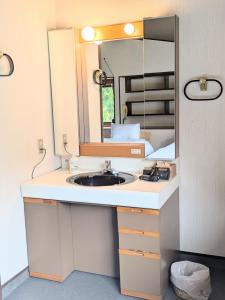 un bagno con lavandino e specchio di Sotoura Resort House 涛Tõ! BBQ-MAX10ppl-4min to Sotoura beach! a Shimoda