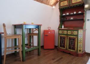 a room with a table and a red refrigerator at Old Town Sibiu Studio - Historical Center Residence in Sibiu