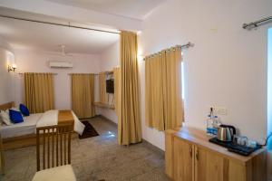 a bedroom with a bed and a table and a window at Devdarshan Hotel & Restaurant in Udaipur