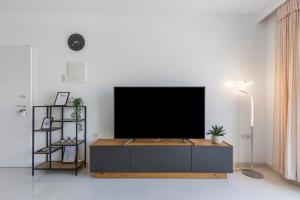 a living room with a flat screen tv on a cabinet at 2BD Coastal Gem with Pool & Terrace - Torre de la Horadada in Torre de la Horadada