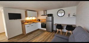 a small kitchen with a refrigerator and a table with chairs at Chez Rinner in Gellin