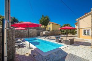 a swimming pool with two umbrellas and chairs and a pool at Villa Mediteran with private pool in Vrh +40 photos