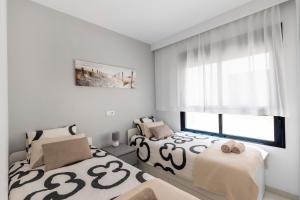a bedroom with two beds and a window at 2BD Coastal Gem with Pool & Terrace - Torre de la Horadada in Torre de la Horadada