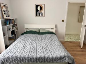 a bedroom with a bed with a gray comforter at A cozy room in family house in Dublin