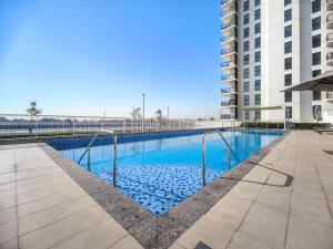a swimming pool in front of a building at FIRST CLASS 1BR Tranquility in Style in Abu Dhabi