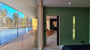 a room with a green wall and a balcony at Villa Aureola in Pyhäjoki