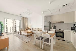 a kitchen and living room with a table and chairs at FIRST CLASS 1BR Tranquility in Style in Abu Dhabi