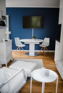 a living room with a white table and a blue wall at Exklusive Ferienwohnung mit Privatterrasse in Plön