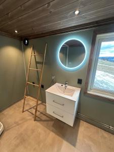 bagno con lavandino, scala e specchio di Cozy little cottage for rent in Oppheim ad Ål
