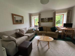 a living room with a couch and a table at Allt-Na-Craig Coach House - Ardrishaig in Ardrishaig