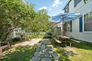 a patio with a bench and an umbrella at Main St Location Walk To Church Landing Pets in Meredith