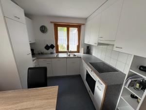 a kitchen with white cabinets and a sink and a window at Chasa Janett in Martinsbruck