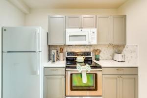 a kitchen with a white refrigerator and a stove top oven at Steps to Shore Studio with Patio in Flagler Beach in Flagler Beach