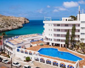 an image of a hotel with a pool and the ocean at Globales Simar in Cala de Sant Vicenc