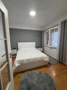 ein Schlafzimmer mit einem weißen Bett und einem Fenster in der Unterkunft Gerald 1 in Tirana