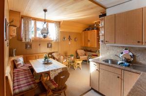 a kitchen with a sink and a table in a room at Chalet Ruedi - CharmingStay in Flumserberg +6 photos