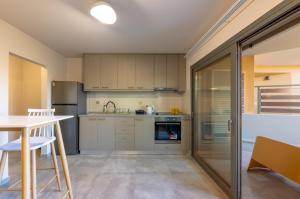 a kitchen with white cabinets and a table at Azure Sofia - Grounded in Kos