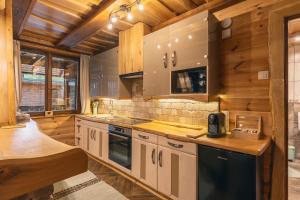 a kitchen with wooden walls and wooden counters at Gerecse Glamping in Tardos
