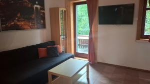 a living room with a couch and a table and a window at Gemütliches 1-Zimmer-Appartment mit Balkon in Markkleeberg