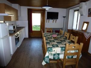 a kitchen and dining room with a table and chairs at Résidence 105 Rue Plaine - Appartement Les Marmottes MAE-1883 in Lanslevillard +2 photos