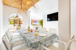 a dining room with a table and white chairs at Exclusive Villa FRANJULY Playa Paraiso Ocean View Private Pool Large Terrace in Adeje