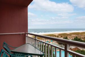 a balcony with a table and a view of the beach at Holiday Inn Ocean City, an IHG Hotel in Ocean City