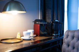 a table with a coffee maker and cups on it at Auberge du Chateau Bleu in Tremblay-En-France