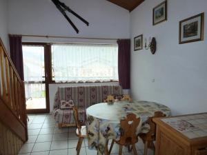 ベッサンにあるRésidence Les Balcons Des Curtious - Studio mezzanine - 4 personnes MAE-2113のテーブルと椅子と窓のあるダイニングルーム